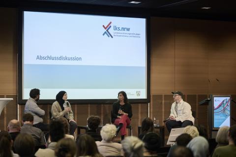 Vier Menschen unterhalten sich auf dem Podium bei der Abschlussdiskusion. 
