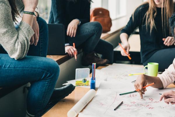 Drei Frauen an einem Tisch konzipieren etwas