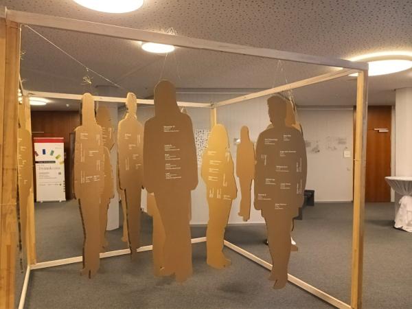 Pappsillhouetten von Menschen als Exponate der Ausstellung