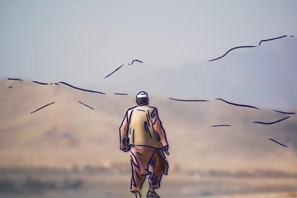 Ein Mann steht vor einer afghanischen Berglandschaft. 