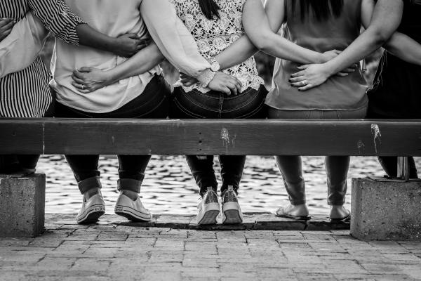 Schwarzweißes BIld von Frauen, die auf einer Bank sitzen