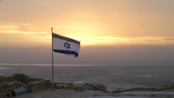 Israelische Flagge vor Landschaft im Sonnenaufgang
