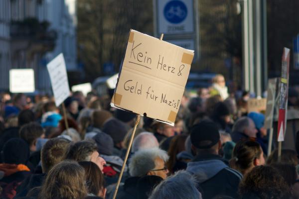 Menschenmenge mit Plakat "Kein Herz & Geld für Nazis"