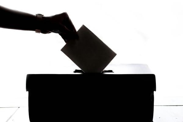 Ein Zettel wird in eine Wahlurne gesteckt