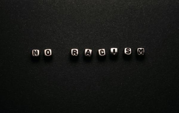 Steine "no racism" vor schwarzem Hintergrund