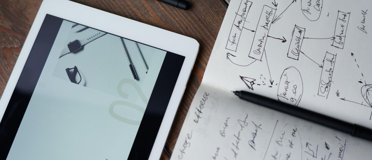 Tablet und Notizbuch auf Tisch