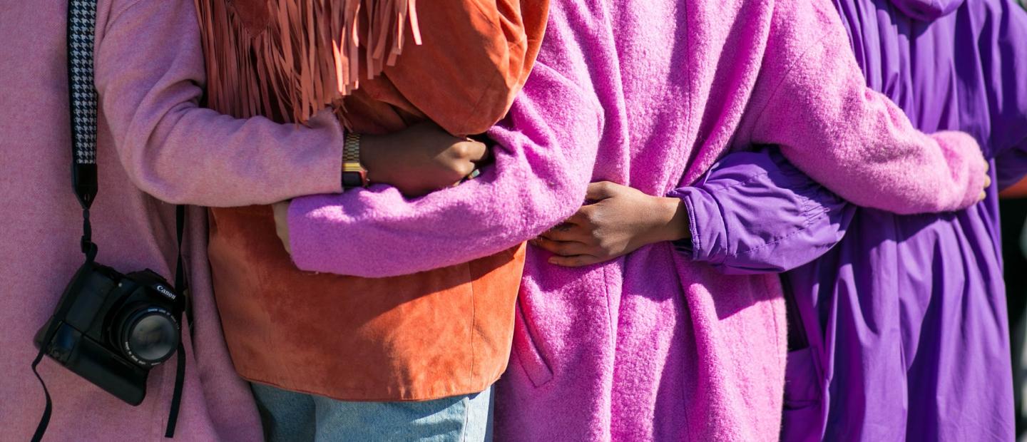 Vier Frauen stehen Arm in Arm